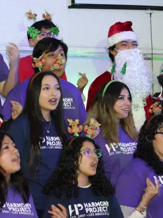 Students wearing holiday headbands and singing.